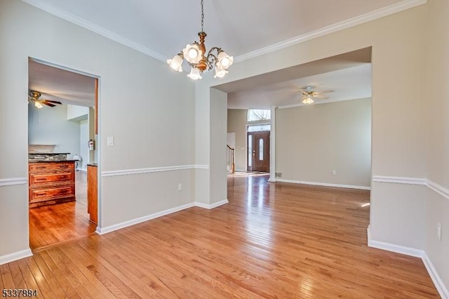 empty room featuring baseboards, light wood-style floors, and ornamental molding