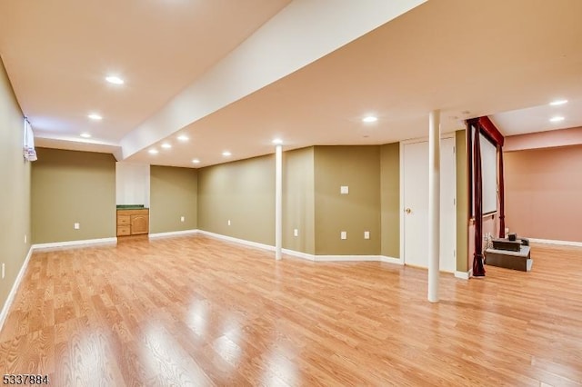 finished basement featuring recessed lighting, light wood-style flooring, and baseboards