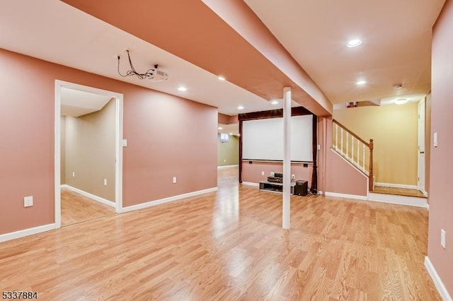 finished basement with light wood finished floors, recessed lighting, stairs, and baseboards