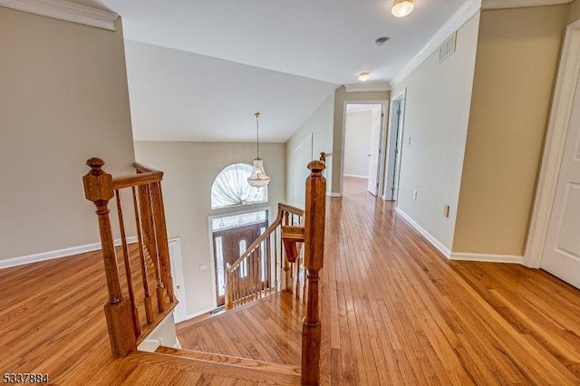 interior space featuring visible vents, baseboards, ornamental molding, an inviting chandelier, and wood finished floors