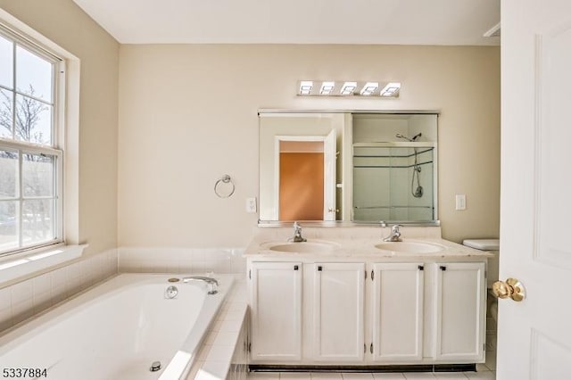 full bath featuring a garden tub, double vanity, a stall shower, and a sink