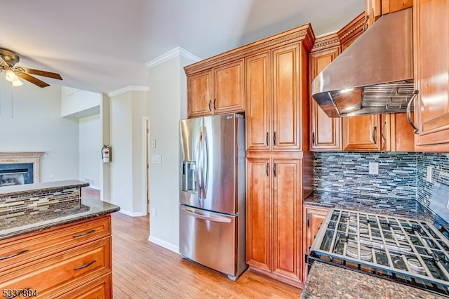 kitchen with a ceiling fan, ornamental molding, decorative backsplash, stainless steel refrigerator with ice dispenser, and exhaust hood