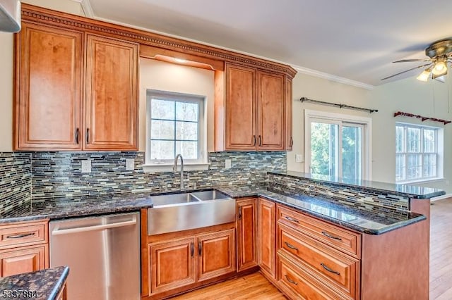 kitchen with a sink, dishwasher, a peninsula, and brown cabinetry