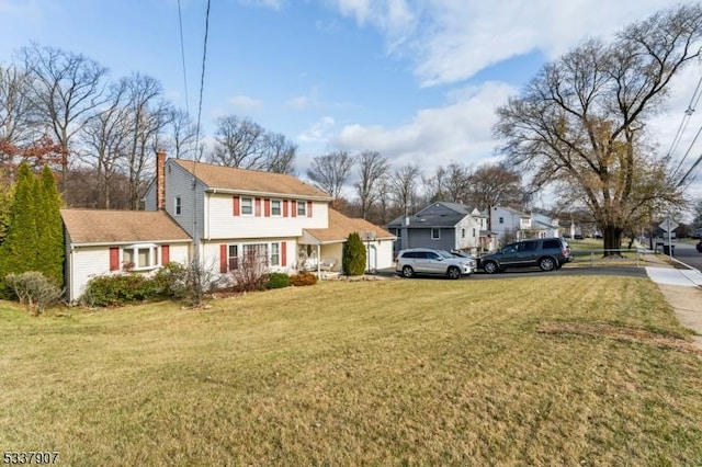 view of front of home featuring a chimney and a front yard