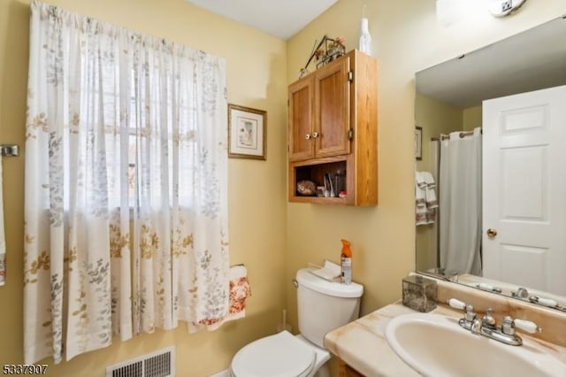 bathroom featuring toilet, visible vents, and vanity