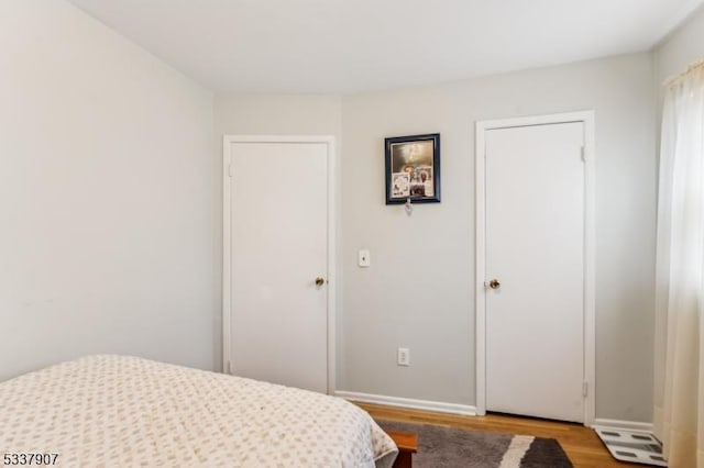 bedroom featuring baseboards and wood finished floors