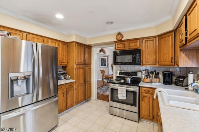 kitchen featuring appliances with stainless steel finishes, brown cabinets, and light countertops