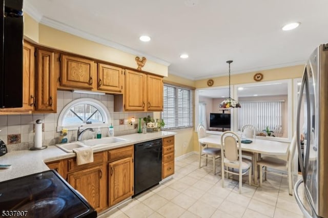 kitchen with tasteful backsplash, light countertops, crown molding, black appliances, and a sink