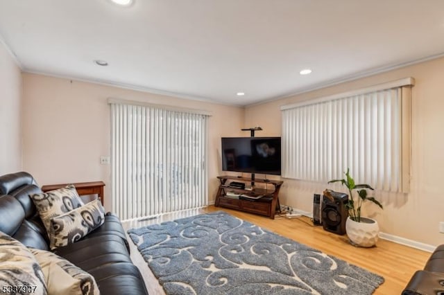 living room featuring ornamental molding, recessed lighting, wood finished floors, and baseboards