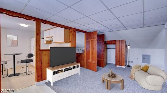 living room featuring electric panel, light carpet, and a drop ceiling