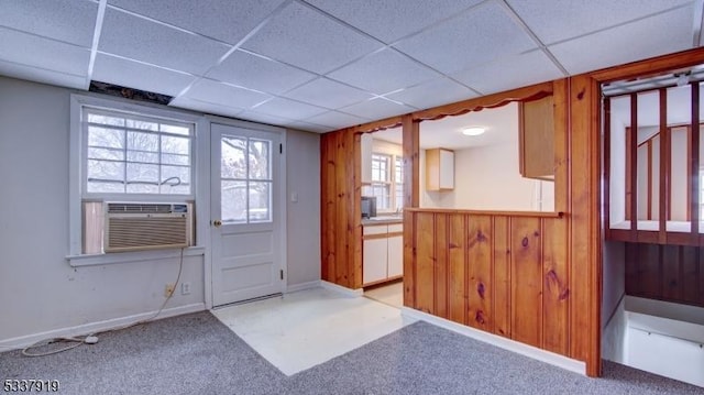 entryway featuring cooling unit, a paneled ceiling, carpet, and wood walls