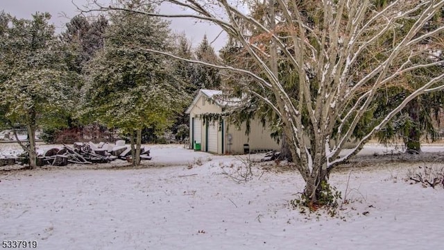 snowy yard with a garage