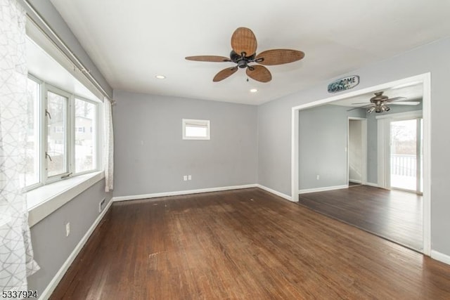 spare room with a wealth of natural light and dark hardwood / wood-style flooring