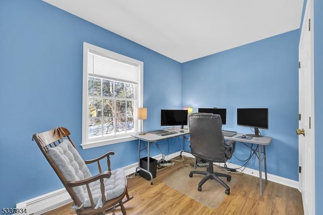 home office featuring a baseboard radiator and hardwood / wood-style floors