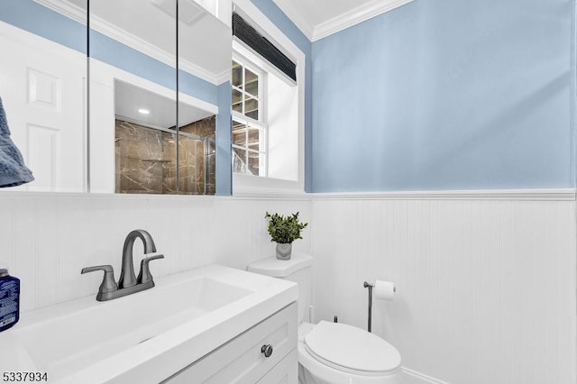 bathroom with vanity, crown molding, and toilet