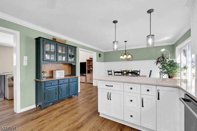 kitchen featuring white cabinetry, ornamental molding, blue cabinetry, and decorative light fixtures