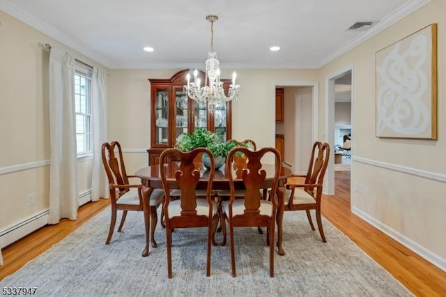 dining space featuring light wood-type flooring, visible vents, and ornamental molding