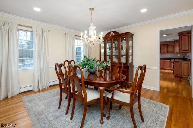 dining area featuring light wood-type flooring, a healthy amount of sunlight, and ornamental molding