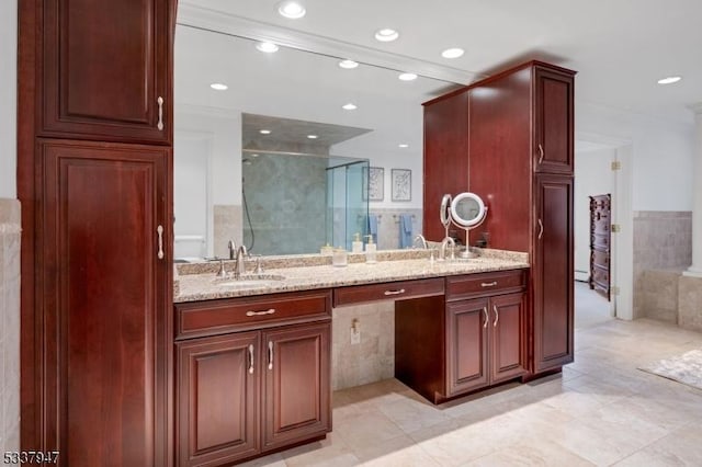 full bath featuring double vanity, a stall shower, a sink, and recessed lighting