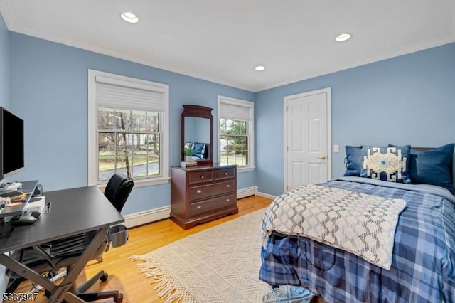 bedroom with ornamental molding, baseboard heating, light wood-type flooring, and baseboards