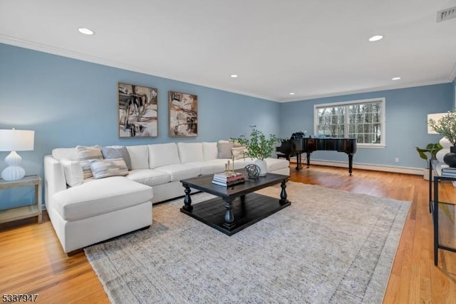 living room with light wood-type flooring, a baseboard radiator, ornamental molding, and recessed lighting