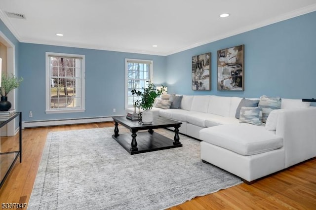 living room featuring visible vents, crown molding, baseboard heating, and wood finished floors