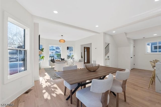 dining area with stairs, light wood-type flooring, visible vents, and baseboards