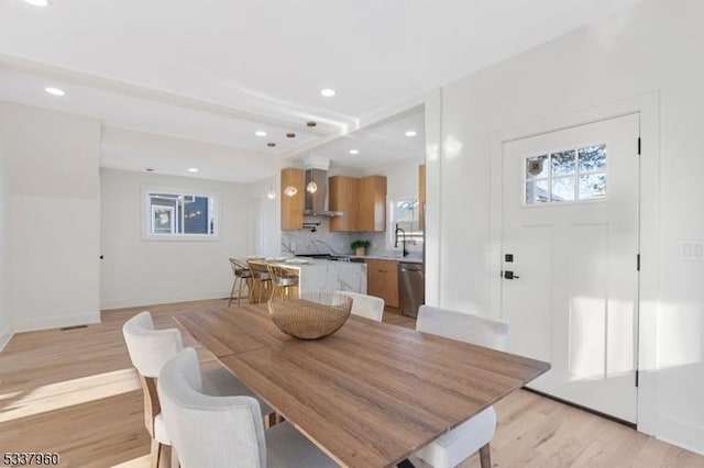 dining space featuring baseboards, light wood finished floors, and recessed lighting