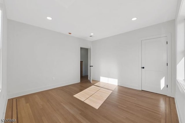 unfurnished room with light wood-style floors, recessed lighting, and baseboards