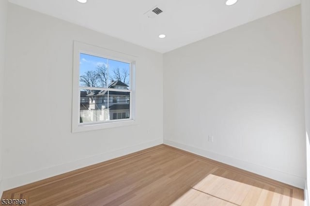 unfurnished room with recessed lighting, visible vents, baseboards, and wood finished floors