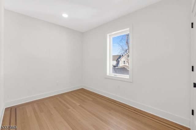 spare room with recessed lighting, baseboards, and wood finished floors