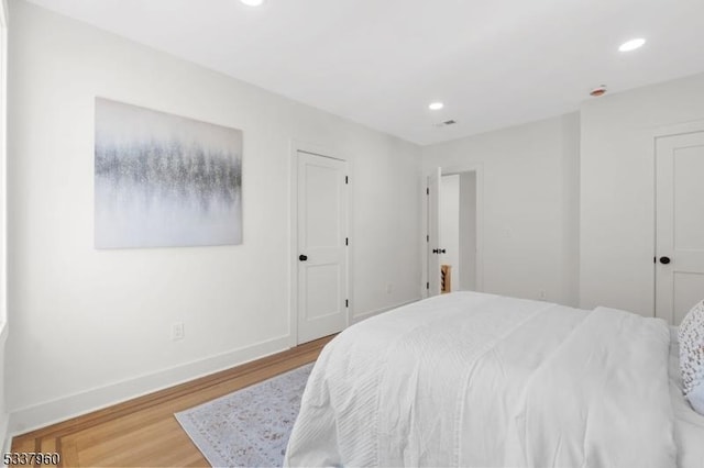 bedroom with recessed lighting, baseboards, and wood finished floors