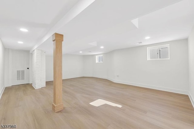 below grade area featuring light wood-style flooring, visible vents, and baseboards