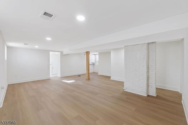 finished below grade area featuring baseboards, recessed lighting, visible vents, and light wood-style floors