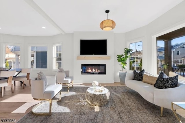 living room with a glass covered fireplace, beam ceiling, recessed lighting, and wood finished floors