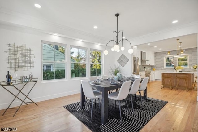 dining space with light hardwood / wood-style flooring and ornamental molding