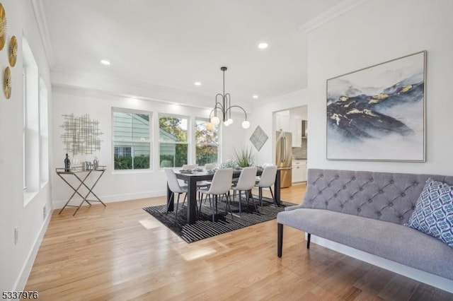 dining room with crown molding and light hardwood / wood-style floors