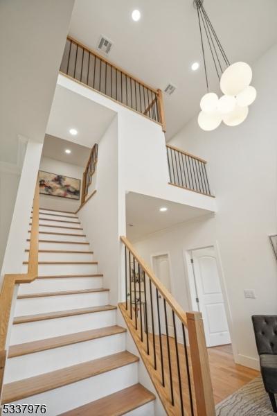 stairway featuring hardwood / wood-style flooring and a high ceiling