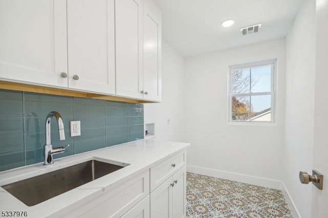 laundry room featuring washer hookup, sink, and cabinets