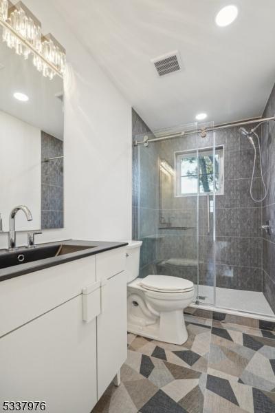 bathroom featuring vanity, toilet, and walk in shower