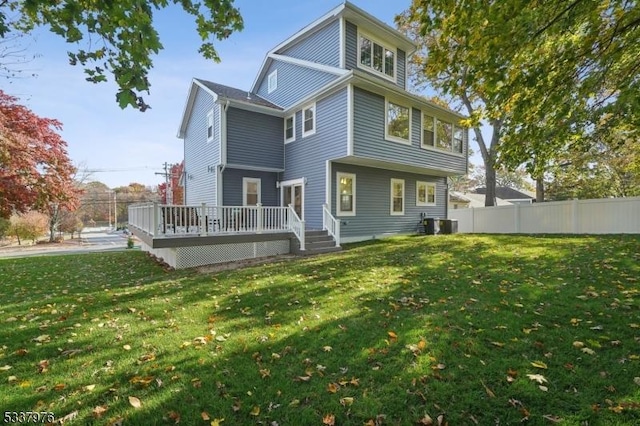 rear view of house featuring a yard and a deck