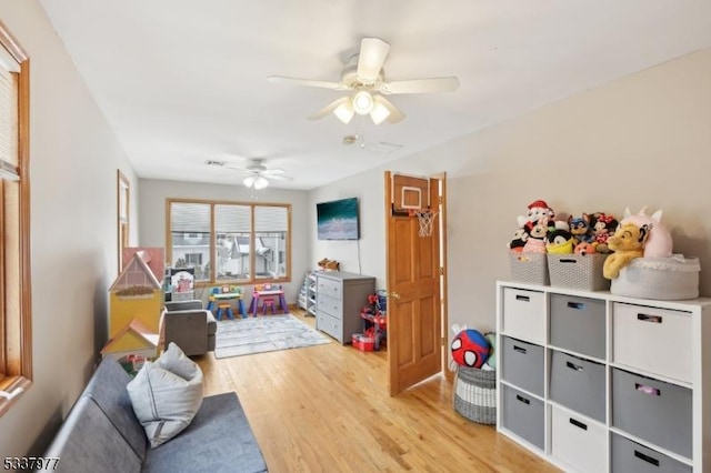 game room with ceiling fan and light wood-type flooring