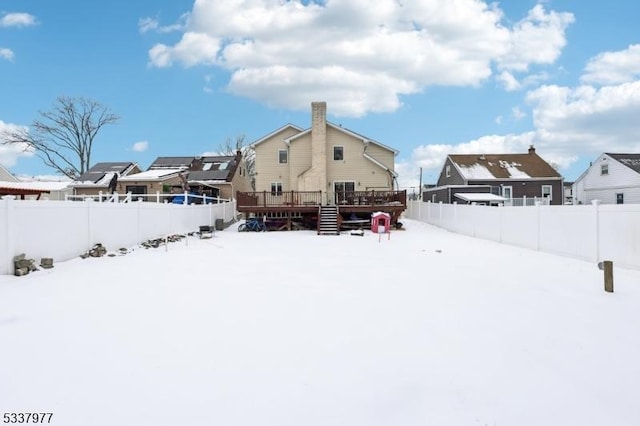 snow covered rear of property with a deck