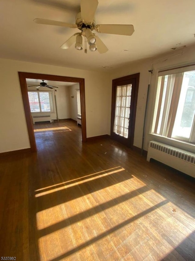 spare room featuring dark wood-type flooring and radiator heating unit