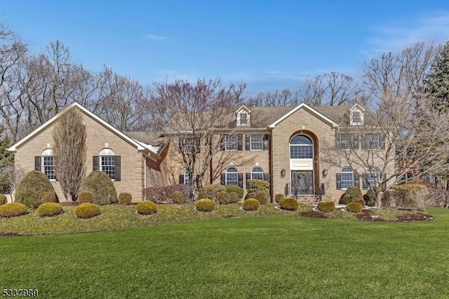 view of front of property featuring brick siding and a front yard