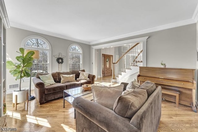 living area with visible vents, ornamental molding, stairway, light wood-style floors, and baseboards