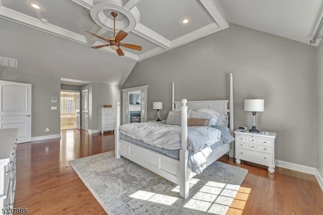 bedroom with visible vents, baseboards, wood finished floors, and vaulted ceiling with beams