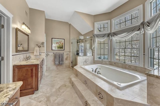 bathroom with vanity, tile walls, a bath, and a stall shower