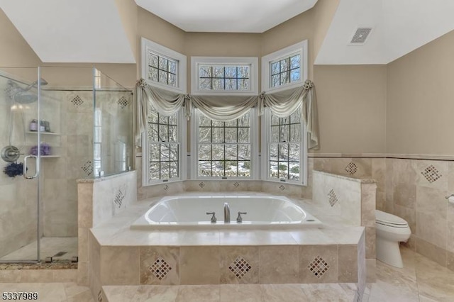 full bathroom featuring visible vents, toilet, a stall shower, tile walls, and a bath