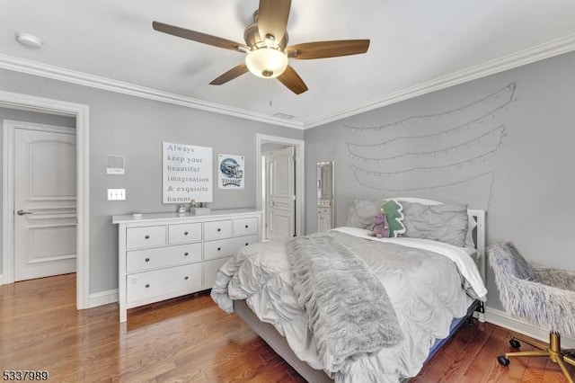 bedroom featuring a ceiling fan, crown molding, baseboards, and wood finished floors